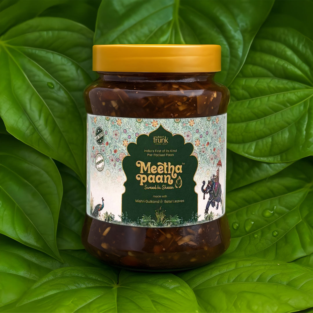 Nature’s Trunk Meetha Paan jar placed on fresh green betel leaves background
